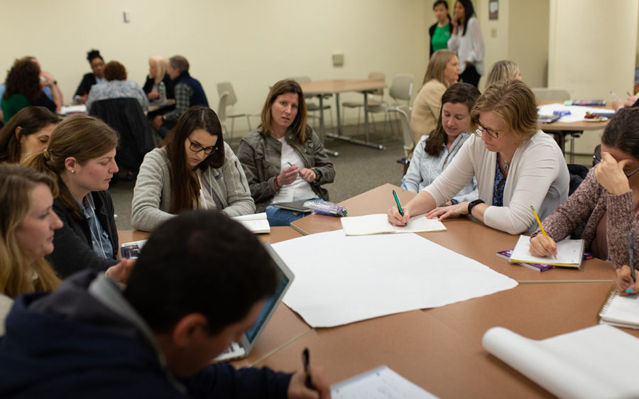 Educators sitting at table and working together at a professional development training.