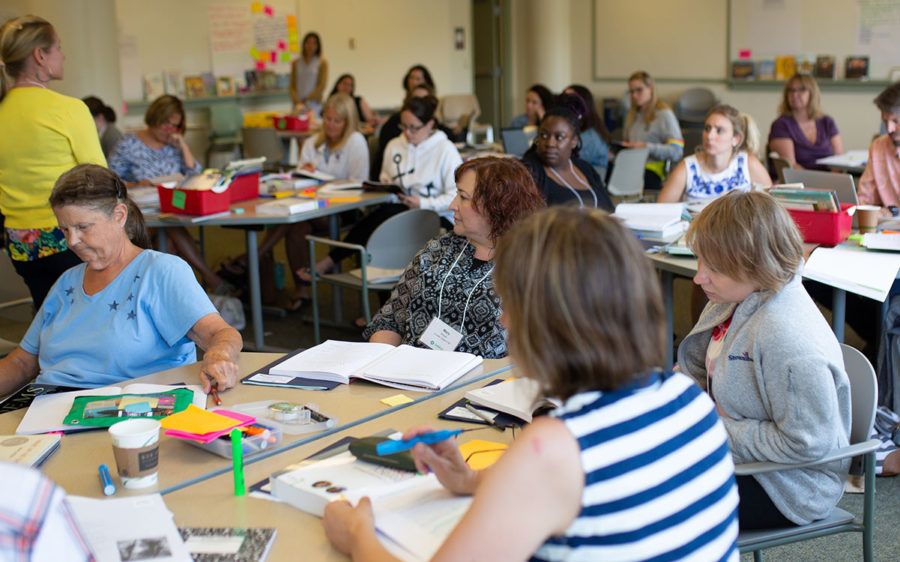 Educators sitting at tables during a professional development training.