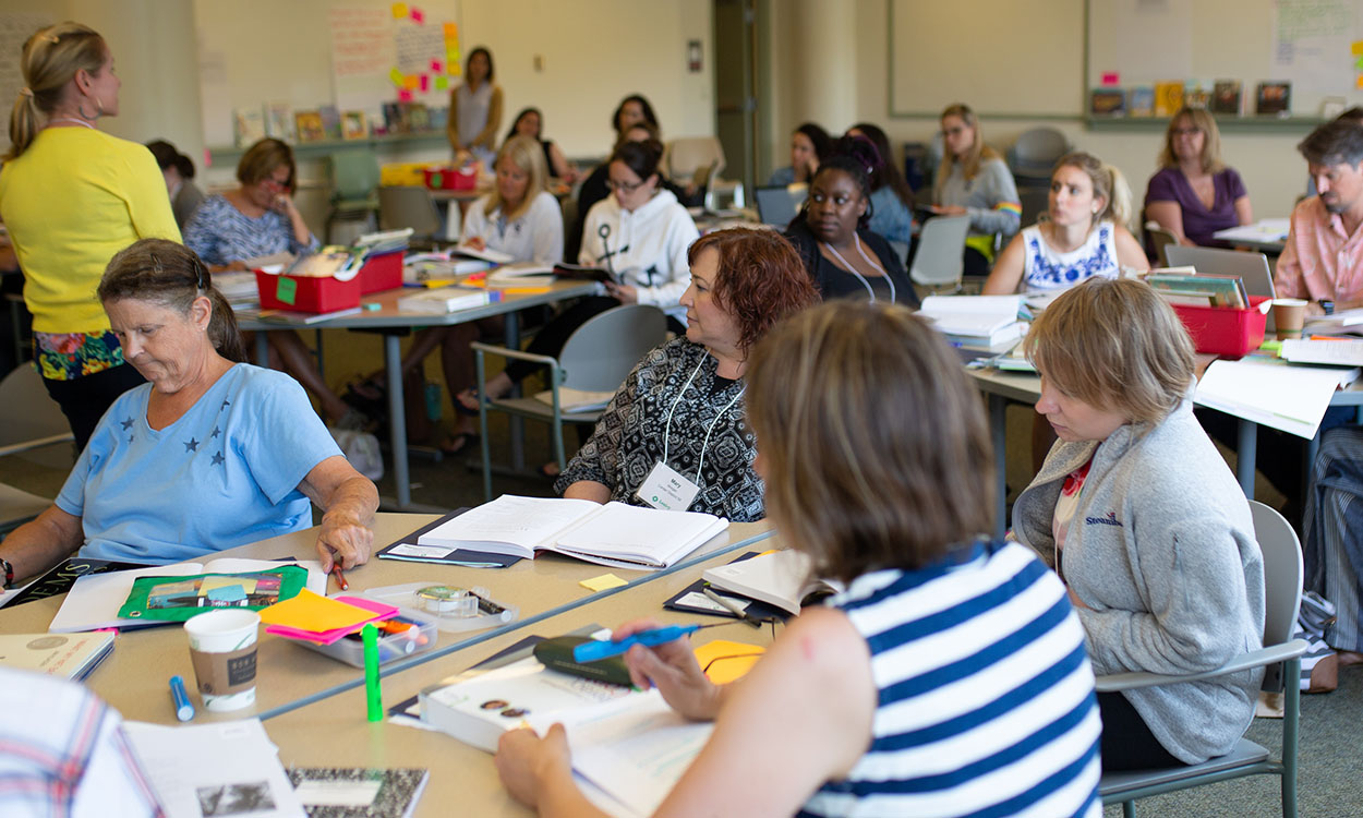 Educators sitting at tables during a professional development training.