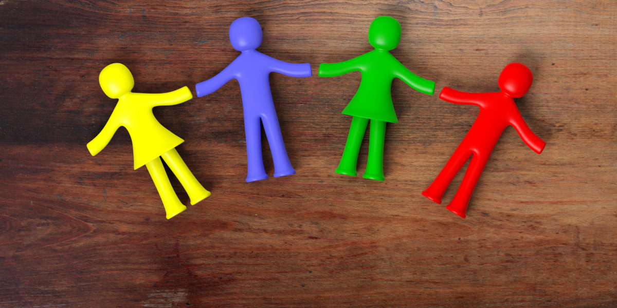 Colorful human figures holding hands laying on wooden background. 3D illustration