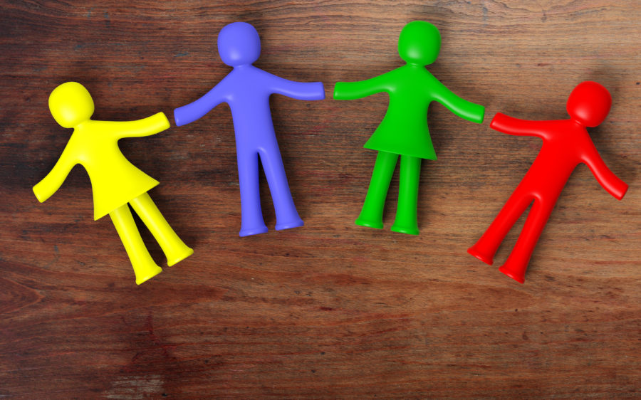 Colorful human figures holding hands laying on wooden background. 3D illustration